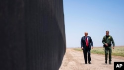 FILE - Then-U.S. Border Patrol chief Rodney Scott gives then-President Donald Trump a tour of a section of the border wall in San Luis, Arizona, June 23, 2020.