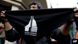 A seller offers handkerchiefs reading in Spanish "Church and state — Separate issues" in Buenos Aires, Argentina, Aug. 18, 2018. People formed lines Saturday as part of a nationwide movement in the homeland of Pope Francis to renounce their religious affiliation.