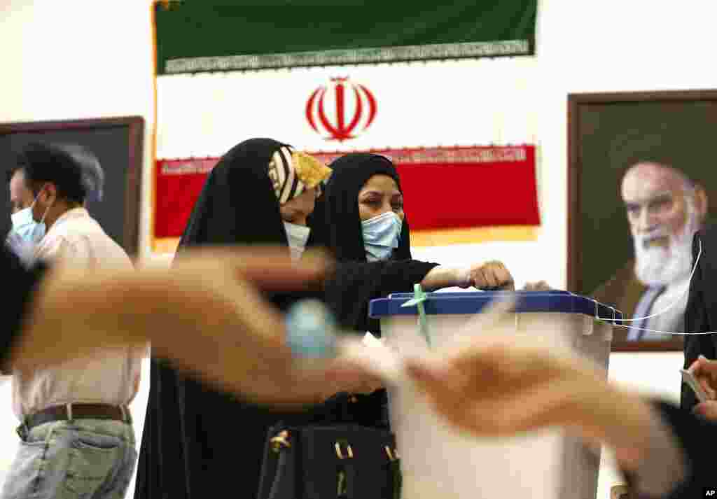 An Iranian woman casts her vote during the presidential election at a polling station inside the Iranian consulate in Karbala, Iraq.tions