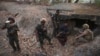 克伦民族解放军和人民防卫军成员在占领克伦邦妙瓦底镇南部一个政府军前哨后对两名被俘士兵进行检查。（2024年3月11日）