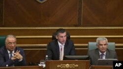 FILE - Parliament Speaker Kadri Veseli, center, addresses Kosovo lawmakers during a debate, Aug. 3, 2015, on constitutional amendments that would allow the establishment of a special court to prosecute its top leaders and former guerrilla fighters for war war crimes in capital Pristina on Monday, Aug. 3, 2015.