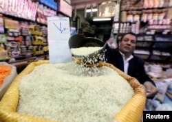 An Egyptian seller shows consumer goods as rice, at a vegetable market in Cairo, Egypt January 10, 2017.
