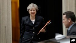 FILE - British Prime Minister Theresa May leaves 10 Downing Street to deliver a statement on Brexit to Parliament in London, Oct. 9, 2017.