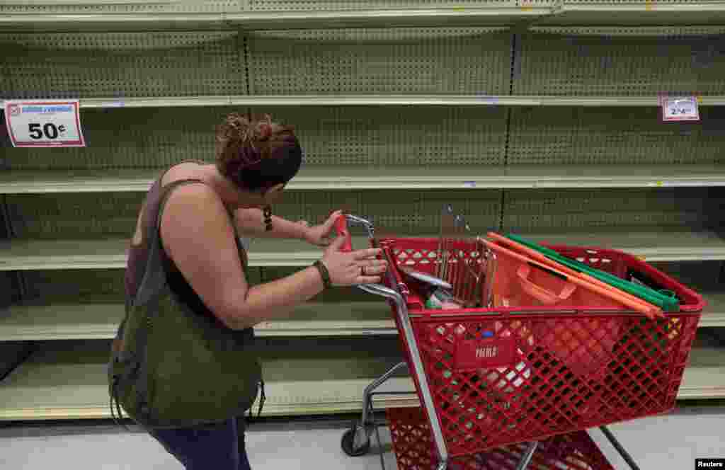 A woman looks at empty shelves that are normally filled with bottles of water after Puerto Rico Governor Ricardo Rossello declared a state of emergency in preparation for Hurricane Irma, in San Juan, Puerto Rico September 4, 2017.
