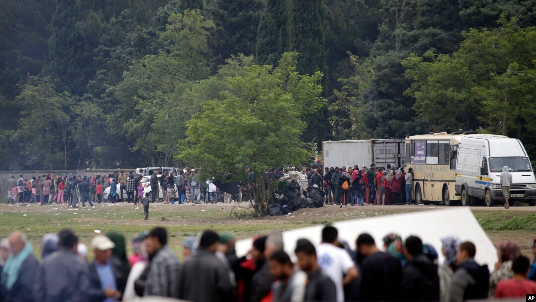 FILE - Migrants and refugees line up for food distribution at the northern Greek border point of Idomeni, Greece, May 2, 2016.