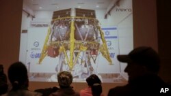 People watch the live broadcast of the SpaceIL spacecraft as it lost contact with Earth in Netanya, Israel, Thursday, April 11, 2019.