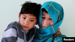 Murtaza Ahmadi, 7, an Afghan Lionel Messi fan and his mother, Shafiqa Ahmadi, 38, pose for a picture at their house in Kabul, Afghanistan, Dec. 8, 2018.