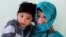 Murtaza Ahmadi, 7, an Afghan Lionel Messi fan and his mother, Shafiqa Ahmadi, 38, pose for a picture at their house in Kabul, Afghanistan, Dec. 8, 2018.