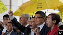 ພວ​ກ​ຜູ້​ນຳ "Occupy Central", ຈາກ​ຊ້າຍ ຫາ​ຂວາ, ​ທັນ​ຍາ ແຈນ, ທ່ານ ແ​ຈນ ຄິນ​ແມນ, ທ່ານ​ເບັນ​ນີ ຕ້າຍ, ​ຄຸນ​ພໍ່ ຈູ ຢີ ມິງ ແລະ ລີ ຫວິງ Tat ​ພາ​ກັນ​ຮ້ອງ​ໂຮ​ຄຳ​ຂວັນ ໃນ​ຮົງ​ກົງ, 19 ພ​ະຈິກ 2018.