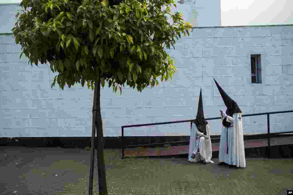 Penitents from the El Cautivo brotherhood wait outside the church to take part in a procession in Seville, Spain, during the Easter Holy Week.