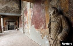 FILE- A damaged statue is seen in the Thermae Stabianae in Pompeii, Italy, March 8, 2012.