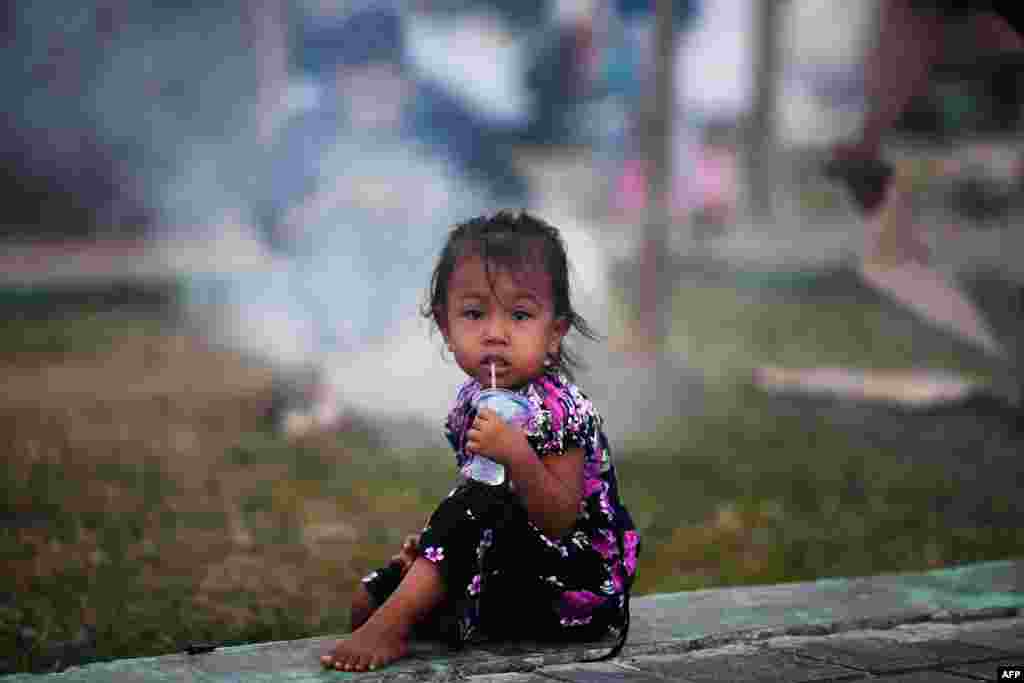 A child drinks water at a camp in Palu, in Indonesia&#39;s Central Sulawesi province, following the September 28 earthquake and tsunami.