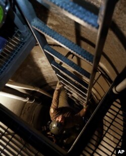 A U.S. Border Patrol agent climbs out of an entrance carved by the agency into a tunnel linking Tijuana, Mexico, and the entrance site in San Diego, Calif., March 6, 2017.