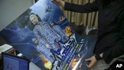 A production assistant for the animated film, "Battle of the Persian Gulf II," holds a poster for the movie, at the office of Farhad Azima, the Iranian director and screenwriter, in Tehran, Iran, Feb. 26, 2017.