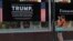 A woman takes a picture of a poster welcoming U.S. President Donald Trump and Russian President Vladimir Putin at a store in downtown Helsinki, July 14, 2018. Trump and Putin will meet Monday at Finnish presidential palace in Helsinki.