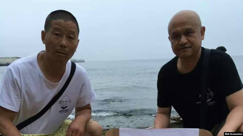姜建军(左)、王承刚在大连老虎滩海边祭奠两天前海葬于附近海域的刘晓波。(2017年7月17日 推特图片)