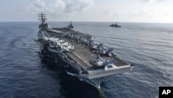 资料照：美国海军公布的照片显示里根号航空母舰与米利厄斯号导弹驱逐舰与日本海上自卫队一道在南中国海进行演习。(2018年8月31日)