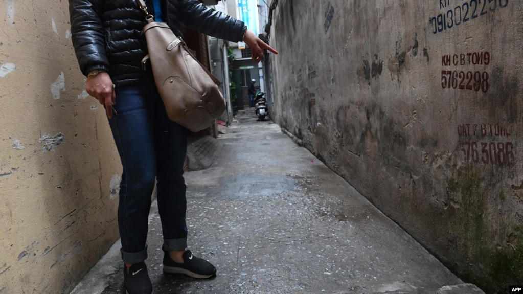 FILE - This photo, taken March 15, 2017, shows a mother pointing to the place where her eight-year-old daughter was molested by a family friend in a residential quarter of Hanoi, Vietnam. Vietnam’s legislation dealing with sexual crimes and human trafficking for years made explicit reference to female victims only; boys were added only recently.