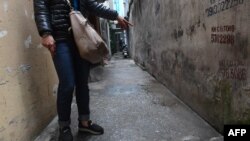FILE - This photo, taken March 15, 2017, shows a mother pointing to the place where her eight-year-old daughter was molested by a family friend in a residential quarter of Hanoi, Vietnam. Vietnam’s legislation dealing with sexual crimes and human trafficking for years made explicit reference to female victims only; boys were added only recently.