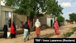 FILE - Women walking on a road in downtown N'Djamena, Chad, Sept. 23, 2017. 