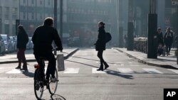 A cyclist pedals in downtown Milan, Italy, Monday, Dec. 28, 2015. Milan has ordered Monday a no-car day to combat pollution, which has hit unhealthy levels for weeks mainly because no rain has fallen to wash away the smog. 