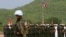 A Cambodian army soldier, foreground, wears a U.N. helmet while standing guard during a U.S.-backed peacekeeping exercise dubbed "Angkor Sentinel 2014" at the Cambodian tank command headquarters in Kampong Speu province, 60 kilometers (37 miles) west of Phnom Penh, Cambodia, Monday, April 21, 2014. The U.S. and Cambodia on Monday commenced Angkor Sentinel, an annual military exercise designed to promote regional peace and security. (AP Photo/Heng Sinith) 