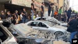 People gather at the scene of an Israeli missile strike in the southern suburbs of Beirut on Sept. 20, 2024. 