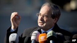 FILE - Syrian Deputy Foreign Minister Faisal Mekdad gestures as he talks to journalists.
