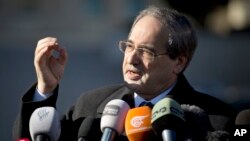 FILE - Syrian Deputy Foreign Minister Faisal Mekdad gestures as he talks to journalists.