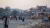 Palestinians walk in a devastated neighborhood due to Israeli strikes in the southern Gaza Strip city of Khan Yunis on Dec. 2, 2024,