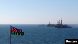 FILE - An Azerbaijan state flag flutters in the wind on an oil platform in the Caspian Sea east of Baku, Jan. 22, 2013. 