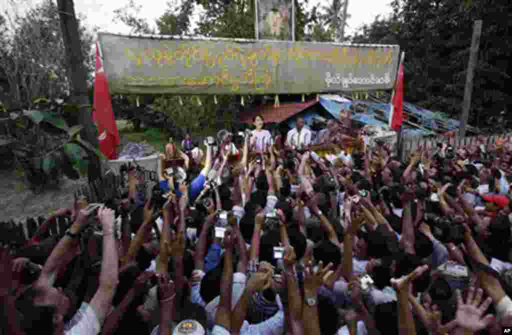 Burma's pro-democracy leader Aung San Suu Kyi addresses her supporters from her house compound after her release from house arrest in Rangoon, 13 Nov 2010.