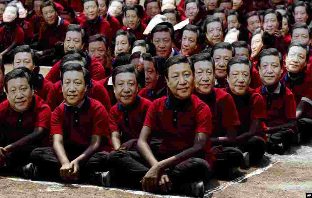 Indian school children wear face masks of Chinese President Xi Jinping to welcome him on the eve of his visit in Chennai.