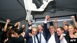 Les candidats nationalistes de Pè a Corsica Jean Guy Talamoni (4ème à partir de la droite) et Gilles Simeoni (5ème) célèbrent leur victoire aux élections territoriales à Bastia, Corse, le 10 décembre 2017.