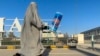 (FILE) An Afghan burqa-clad woman walks past an energy drink advertisement at Kandahar airport in Kandahar, on August 29, 2024.