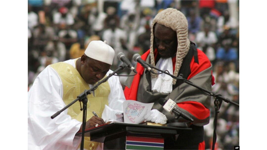 FILE - Gambia President Adama Barrow, left, signs a document during his inauguration ceremony in Banjul, Feb. 18, 2017.