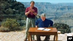 ໃນພາບຖ່າຍເມື່ອວັນທີ 18 ກັນຍາ 1996 ນີ້, ຮອງປະທານາທິບໍດີ ທ່ານ Al Gore ຕົບມື ຫຼັງຈາກປະທານາທິບໍດີ ທ່ານ Bill Clinton ລົງນາມຮ່າງກົດໝາຍ ທີ່ກຳນົດ ເນື້ອທີ່ປະມານ 1.7 ລ້ານເອເກີ້ ຂອງດິນພູຜາ ໃນພາກໃຕ້ ຂອງລັດ Utah ໃຫ່ເປັນເຂດສະຫງວນແຫ່ງຊາດ Grand Staircase-Escalante, ຢູ່ທີ່ອຸດທະຍານແຫ່ງຊາດ Grand Canyon ໃນລັດ Arizona. 