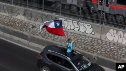Un manifestante agita una bandera chilena durante una protesta este 25 de octubre de 2019 contra los precios de los peajes de carreteras en Santiago de Chile.