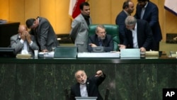 Head of Iran's Atomic Energy Organization Ali Akbar Salehi, bottom, speaks in an open session of parliament while discussing a bill on country's nuclear deal with world powers, in Tehran, Oct. 11, 2015.