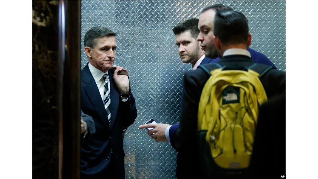 FILE - Retired Lt. Gen Michael Flynn, left, his son Michael G. Flynn, second from left, and Boris Epshteyn, a spokesman for President-elect Donald Trump, third from left, board an elevator at Trump Tower in New York.