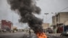 Des pneus brûlent alors que les manifestants barricadent les rues de Cadjehoun, fief de l'ancien président du Bénin, Thomas Yayi Boni, le 2 mai 2019 à Cotonou.