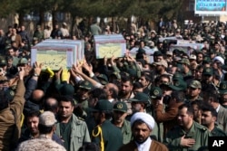 Civilians and armed forces members carry the flag-draped coffins of Iranian Revolutionary Guard's Gen. Mohsen Ghajarian, left, and some of his comrades who were killed in fighting in Syria, during their funeral ceremony in Tehran, Iran, Feb. 6, 2016.
