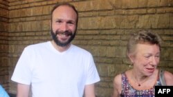 French Roman Catholic priest Georges Vandenbeusch (L) smiles on Dec. 31, 2013 next to French Ambassador to Cameroon Christine Robichon as he arrives at the French ambassador's residence in Yaounde after being freed following a six-week ordeal. 