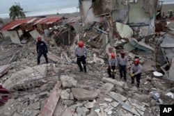 Ecuadorean firefighters comb through rubble of buildings destroyed by a 7.8-magnitude earthquake in Pedernales, April 22, 2016.