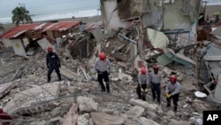 Anggota pemadam kebakaran Ekuador menyisir bangunan yang hancur oleh gempabumi dengan kekuatan 7,8 SR. Pedernales, Ekuador.