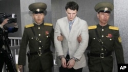 American student Otto Warmbier, center, is escorted at the Supreme Court in Pyongyang, North Korea, March 16, 2016. North Korea's highest court sentenced Warmbier to 15 years in prison after he allegedly attempted to steal a propaganda banner.