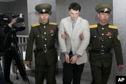 Mahasiswa AS, Otto Warmbier (tengah), dikawal di Mahkamah Agung di Pyongyang, Korea Utara, 16 Maret 2016. Wambier dijatuhi hukuman 15 tahun penjara oleh MA Korea Utara setelah dituduh mencoba mencuri spanduk propaganda.