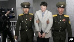 American student Otto Warmbier, center, is escorted at the Supreme Court in Pyongyang, North Korea, March 16, 2016. North Korea's highest court sentenced Warmbier to 15 years in prison after he allegedly attempted to steal a propaganda banner.