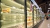 A shopper walks past partially empty frozen food coolers at a grocery in Cranberry Township, Pennsylvania, on Jan. 11, 2022. 