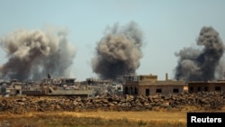 FILE - Smoke rises from al-Harak town, as seen from Deraa countryside, Syria, June 25, 2018. 